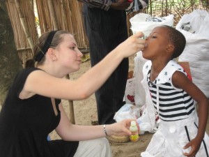 Natalie giving vitamins to orphaned girl back in 2009