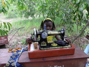 Orphaned girl learning tailoring in the outdoors