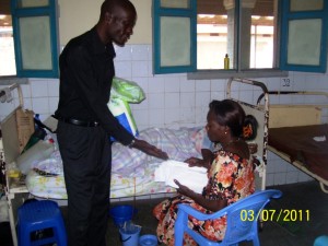 Etienne distributing goods to patients in hospital and praying for them