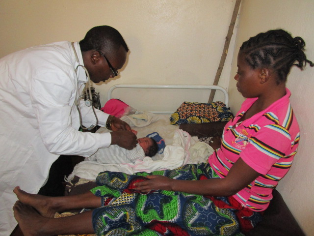Medical doctor giving check-up to another newborn baby.