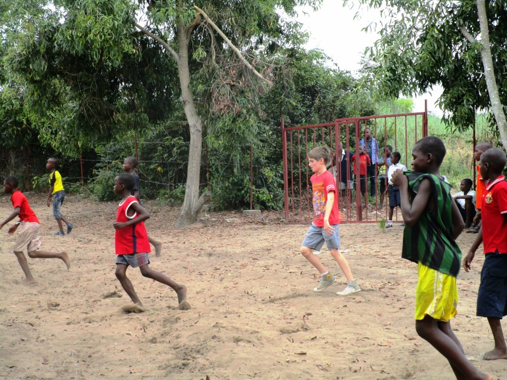 Caleb playing soccer with Kikimi children