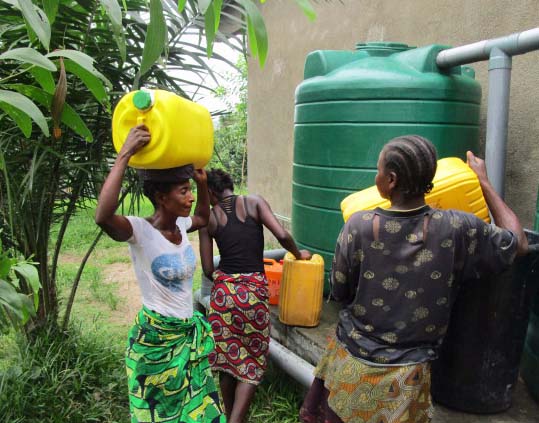 Les femmes du village vont puiser de l'eau à la source pour les travaux de maçonnerie