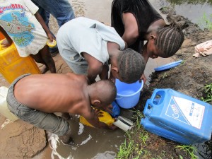 Kikimi children collecting unclean water at the spring