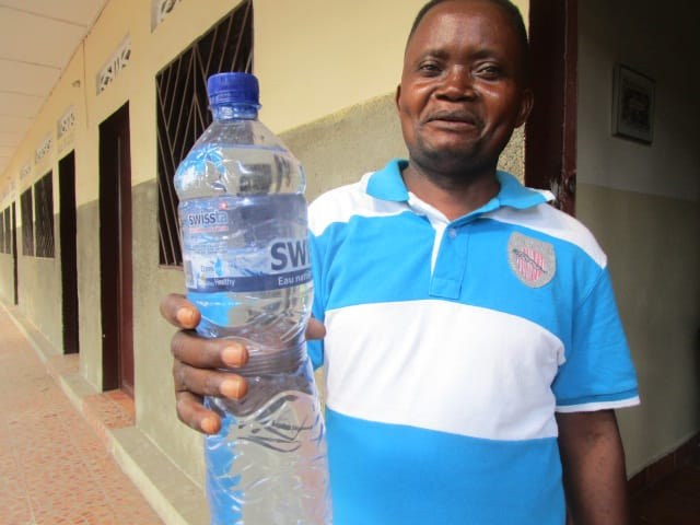 Proud engineer filling the first bottle of water to be taken to lab for testing.