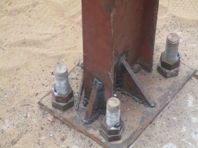 Bolting metallic frame to foundation 